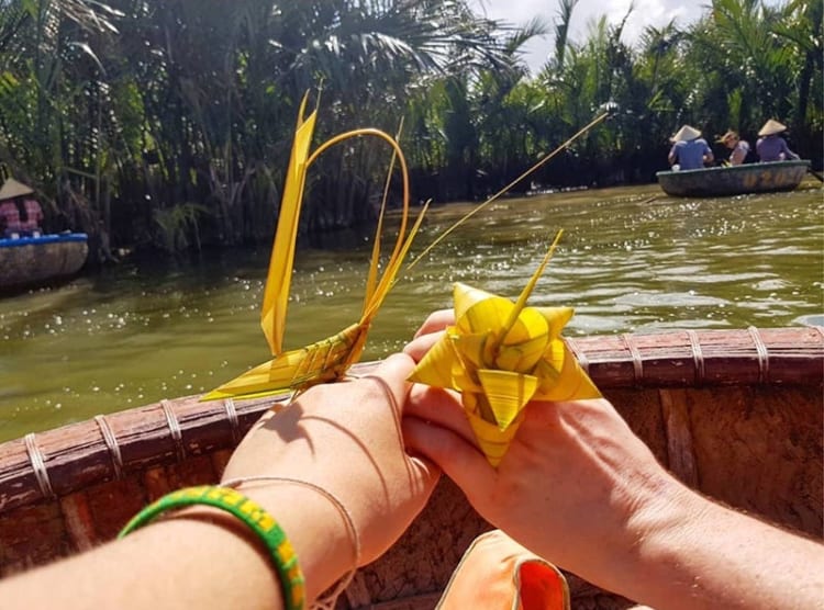 A visitor makes flower using coconut leaves