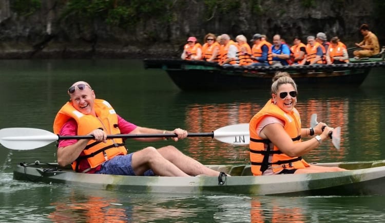 Families create lasting memories kayaking together in the calm waters of Ha Long Bay.